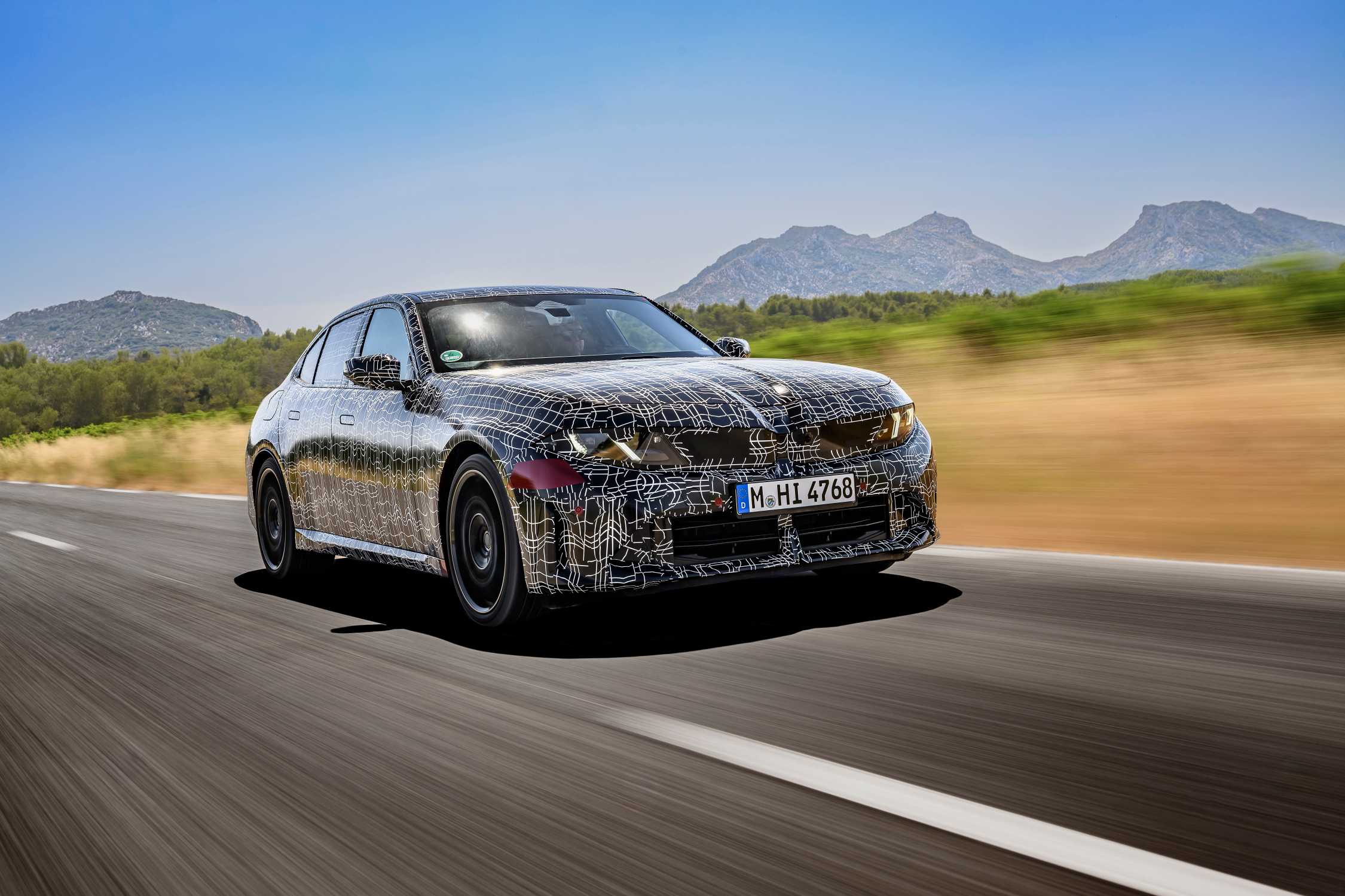 BMW press photo: camouflaged next-generation 3 Series prototype.