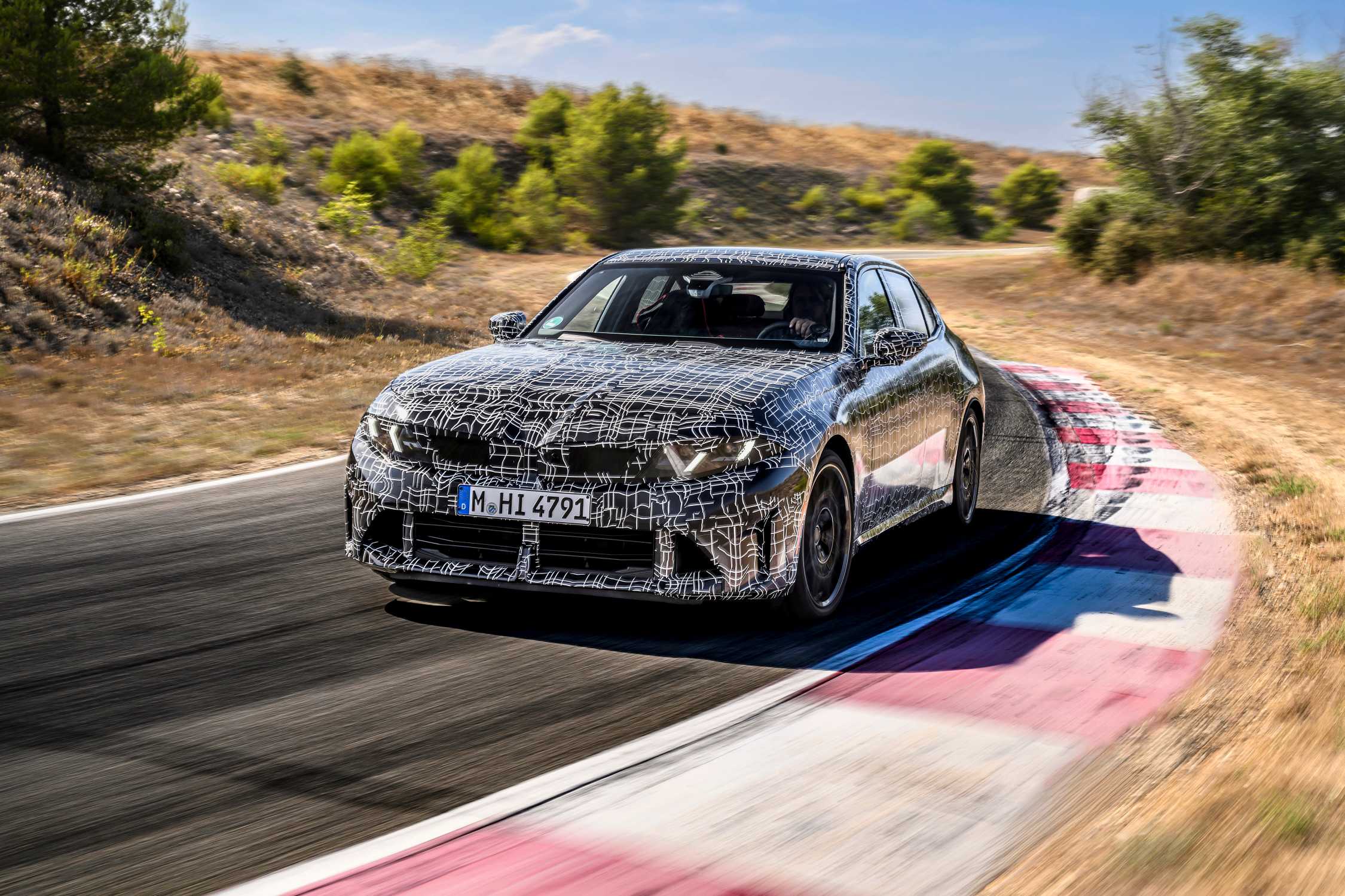 Official BMW development photo: camouflaged prototype, not final showroom trim.